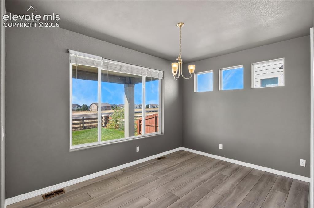 Image 10 of 35: Hardwood-finish flooring, recessed lighting, and a multi-pane window with b