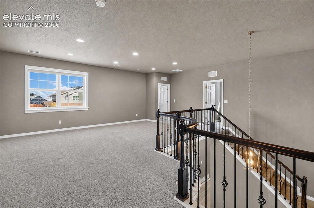 Image 13 of 35: Expansive upper-level bonus room with plush carpeting, recessed lighting, a