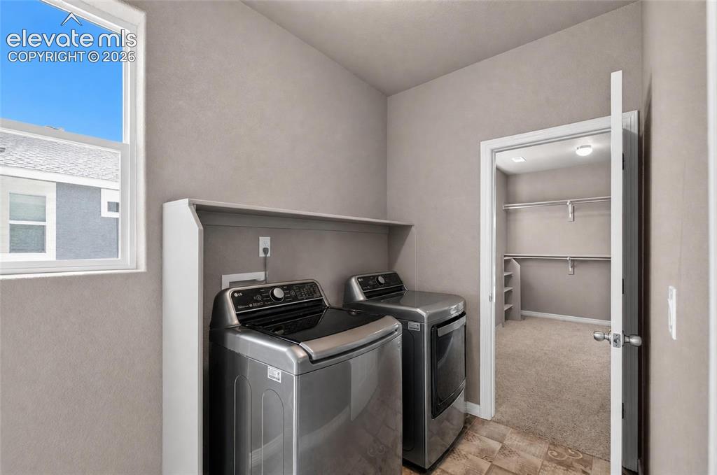 Image 19 of 35: Laundry area featuring a window, built-in shelving, durable flooring, and c