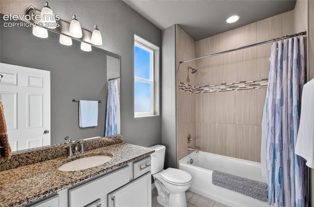 Image 22 of 35: Bathroom featuring a vanity with a granite-style countertop, undermount sin