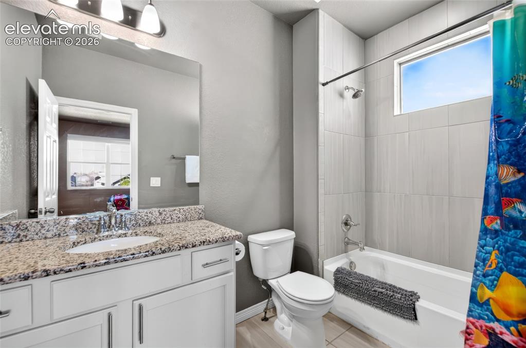 Image 23 of 35: Vanity with a speckled countertop, undermount sink, and chrome faucet