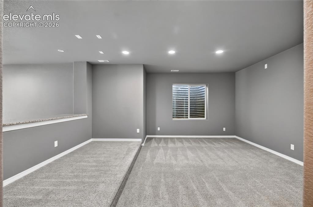 Image 25 of 35: Recessed lighting, light gray wall color, gray patterned carpeting, white w