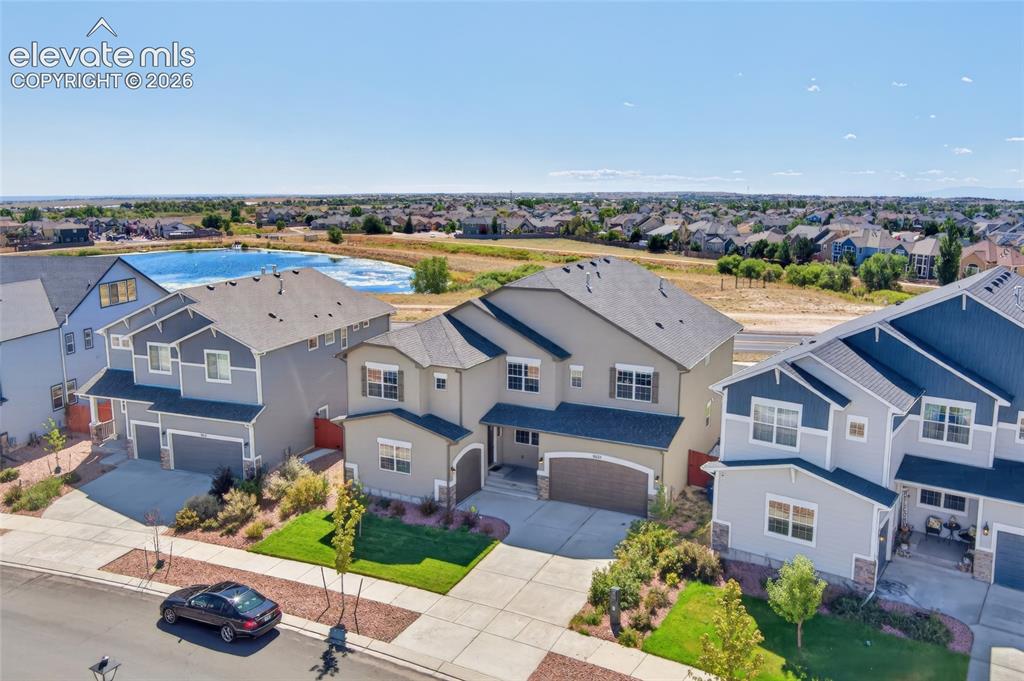 Image 28 of 35: Two-story residence with a two-car garage, mature landscaping, and an adjac