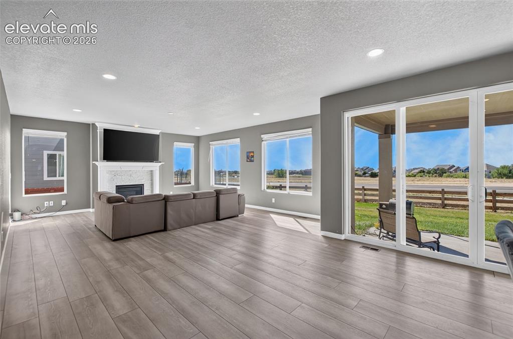 Image 6 of 35: Spacious living area featuring wood-finish flooring, recessed lighting, and