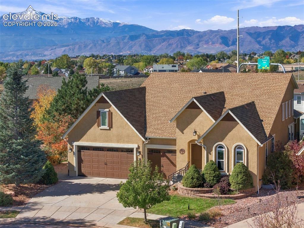 Image 1 of 48: Stucco exterior featuring a multi-gabled roofline, an attached three-car ga