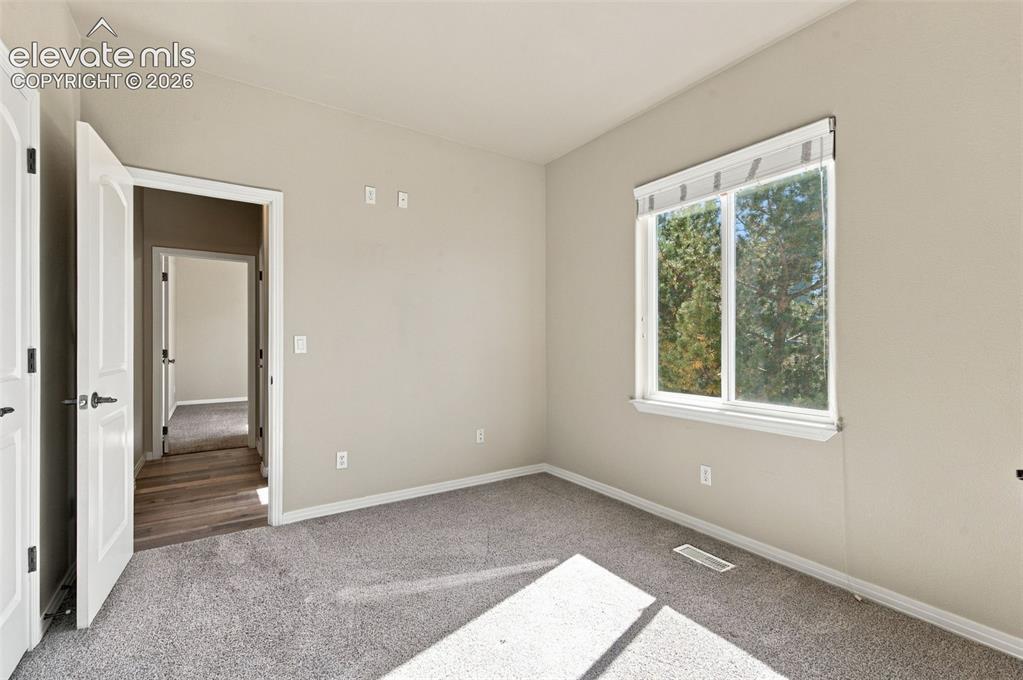 Image 25 of 48: Neutral-toned interior featuring wall-to-wall carpeting, a dual-pane slidin