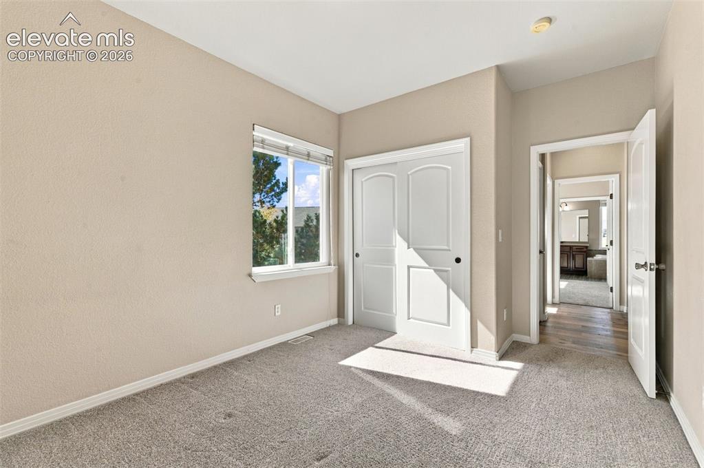 Image 27 of 48: Neutral-toned interior featuring wall-to-wall carpeting, dual-pane window w