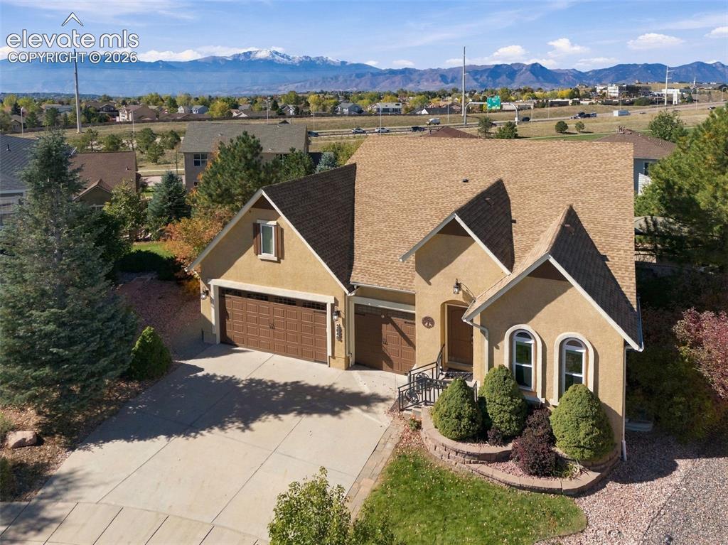 Image 3 of 48: Stucco exterior with multi-gabled roofline, three-car garage, concrete driv