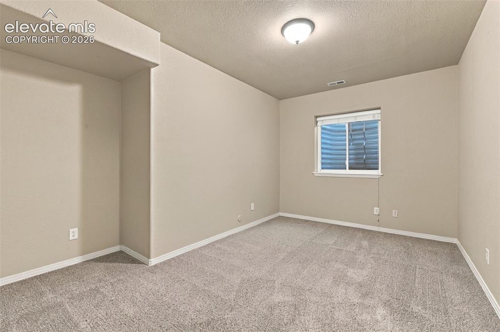 Image 34 of 48: Interior room featuring neutral wall paint, carpeted flooring, a recessed n