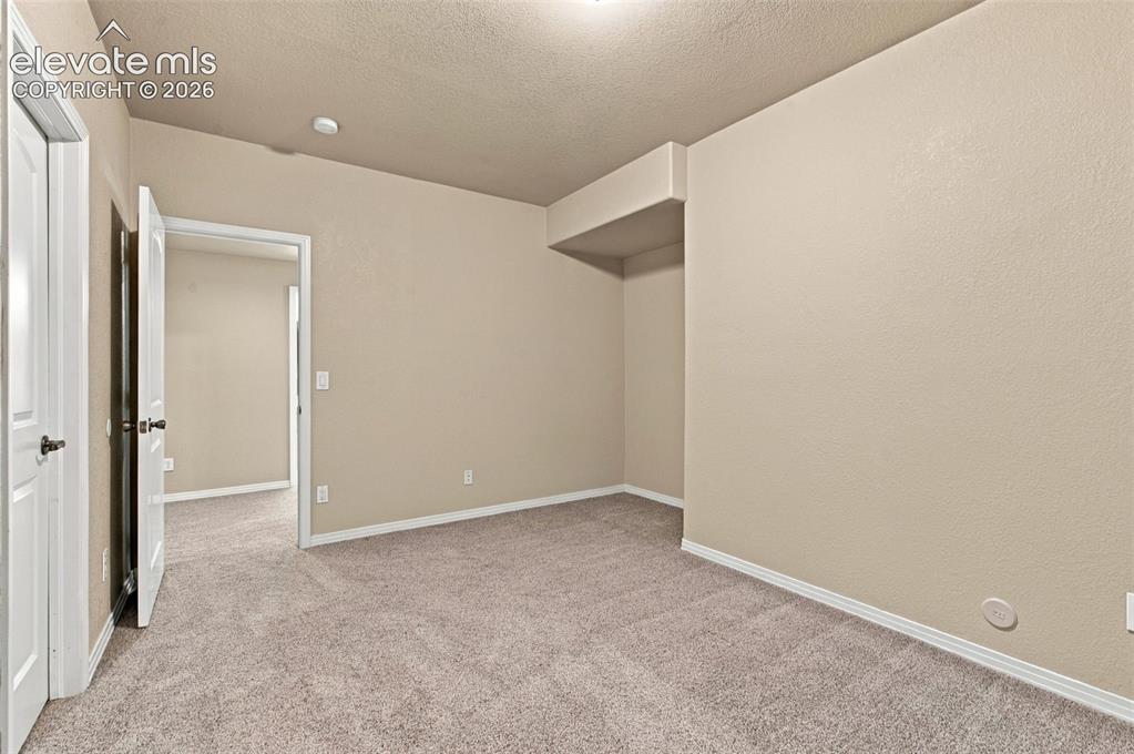 Image 35 of 48: Neutral wall-to-wall carpeting, recessed architectural alcove, and six-pane
