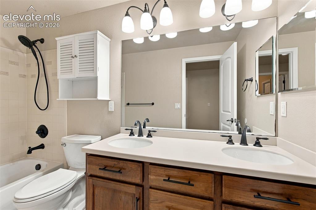 Image 36 of 48: Bathroom featuring a dual-sink vanity with matte black hardware, a large wa