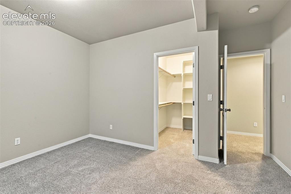 Image 39 of 48: Neutral-toned interior room featuring wall-to-wall carpeting, an open walk-