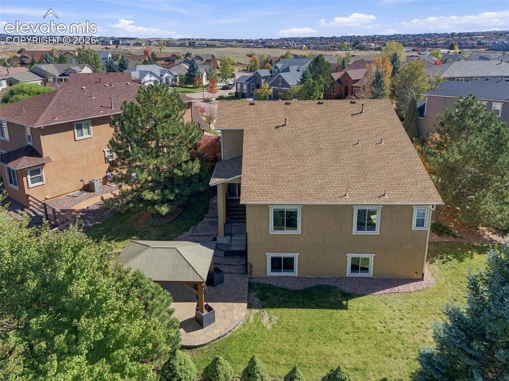 Image 47 of 48: Rear exterior featuring a multi-level stucco facade, asphalt shingle roof, 