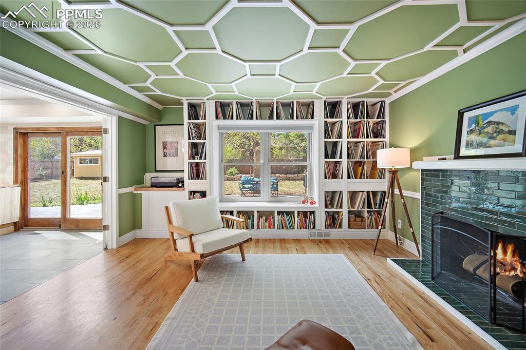 Image 19 of 50: French doors and beautiful tiled wood burning fireplace. 