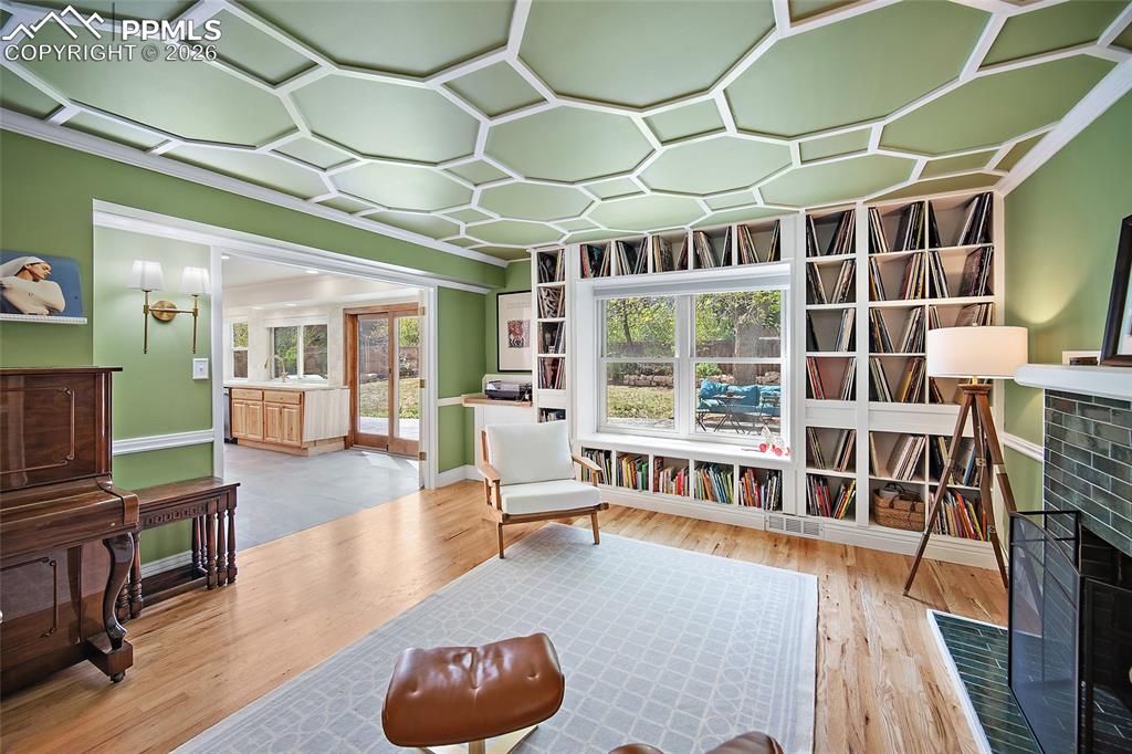 Image 20 of 50: Den/music room with French doors and wood burning fireplace and built in sh