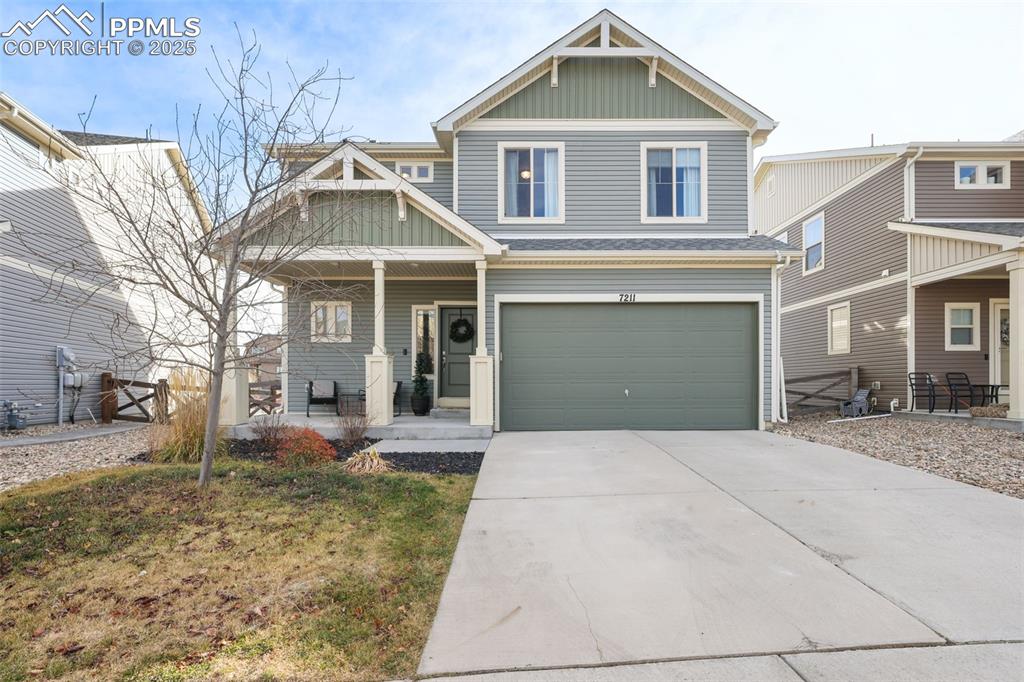 Caption: Craftsman house featuring a porch, board and batten siding, concrete driveway, and an attached garag