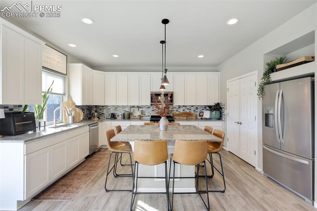 Image 11 of 39: Kitchen with appliances with stainless steel finishes, white cabinetry, a k
