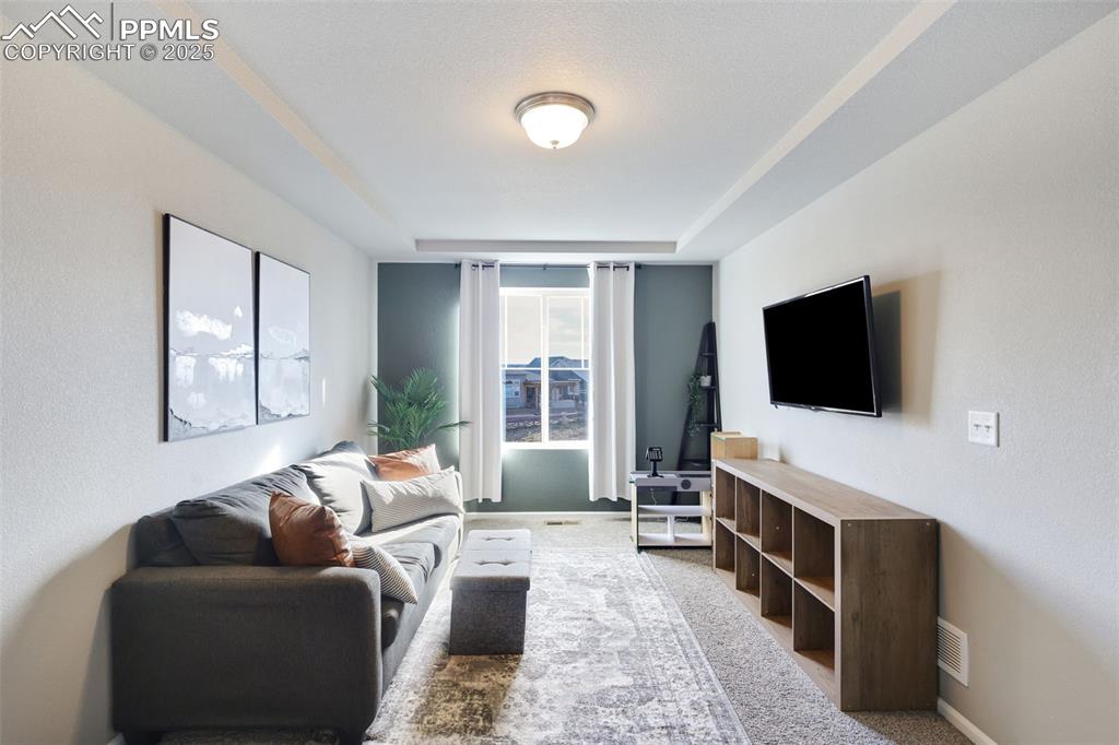 Image 15 of 39: Living room featuring light colored carpet and baseboards