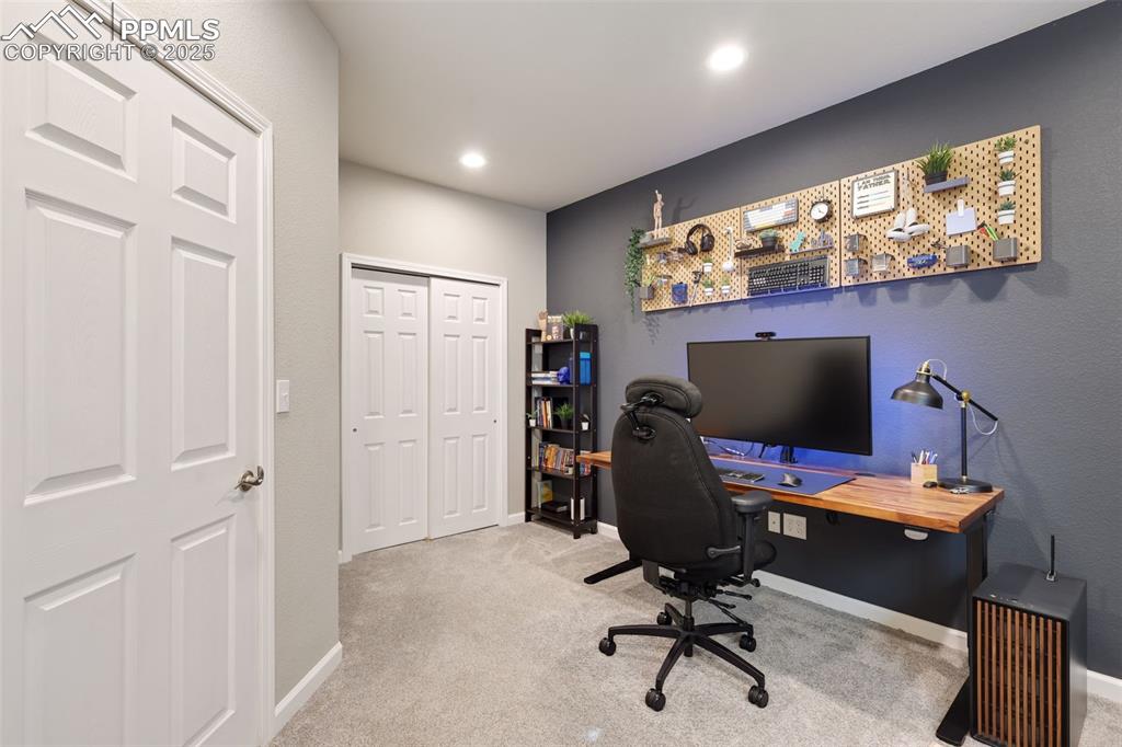 Image 31 of 39: Home office with light colored carpet and recessed lighting