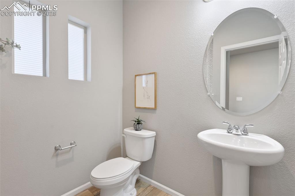 Image 7 of 39: Bathroom with a textured wall and light wood-type flooring