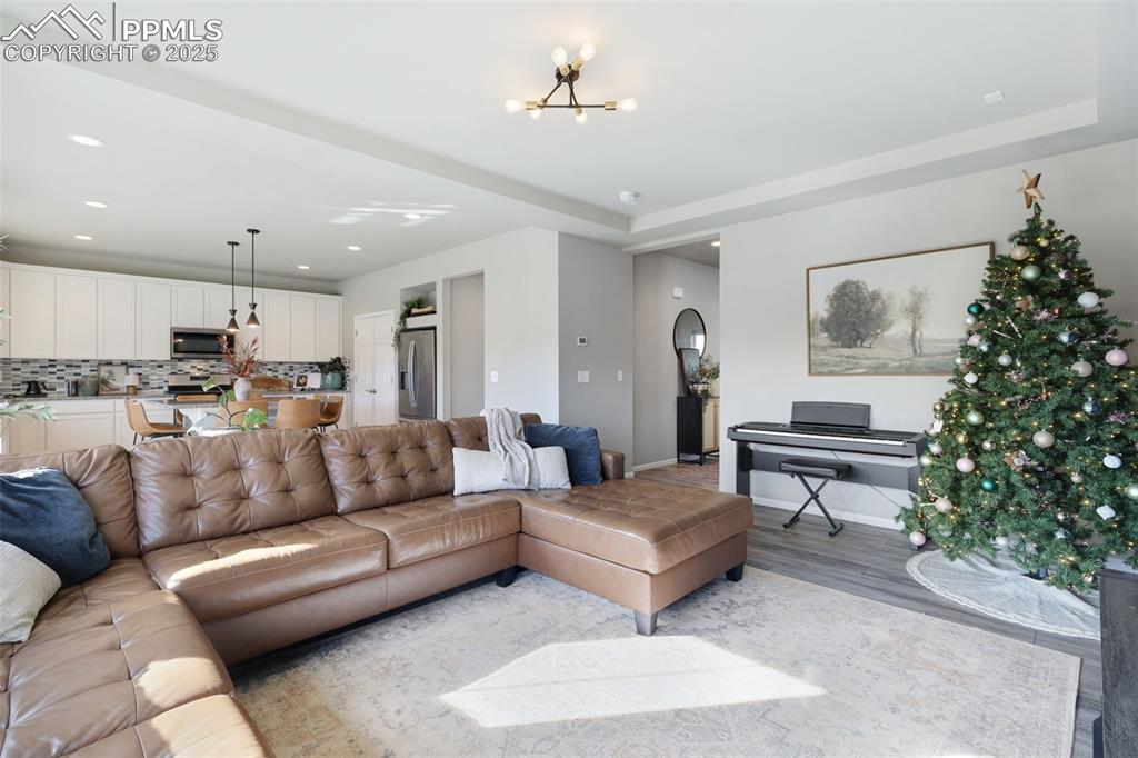 Image 9 of 39: Living room featuring recessed lighting, a chandelier, and wood finished fl
