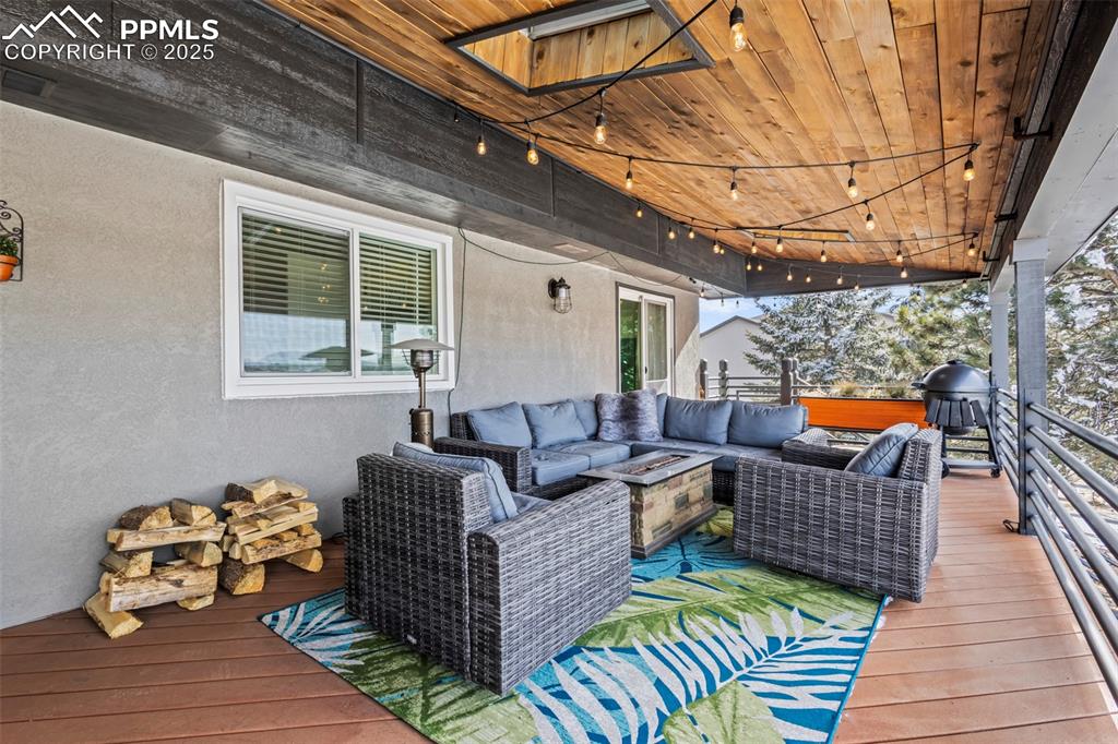 Image 13 of 49: Wooden terrace featuring grilling area and an outdoor hangout area