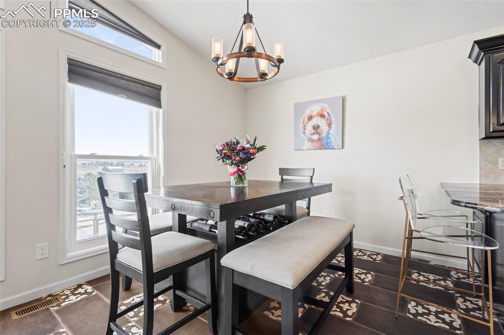 Image 18 of 49: Dining space featuring an inviting chandelier, visible vents, and baseboard