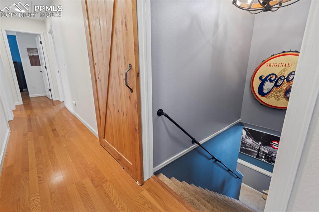 Image 19 of 49: Stairway with baseboards and wood finished floors