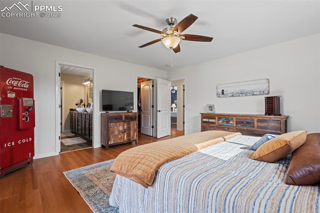 Image 21 of 49: Bedroom with connected bathroom, dark wood-style flooring, a ceiling fan, b