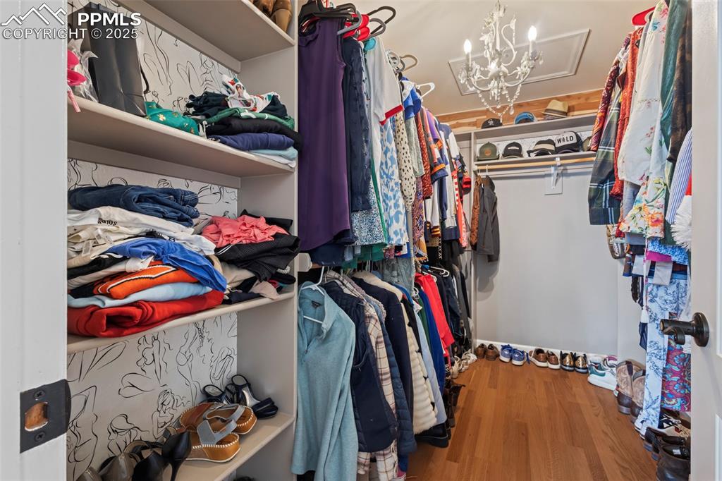 Image 24 of 49: Spacious closet featuring a chandelier and wood finished floors