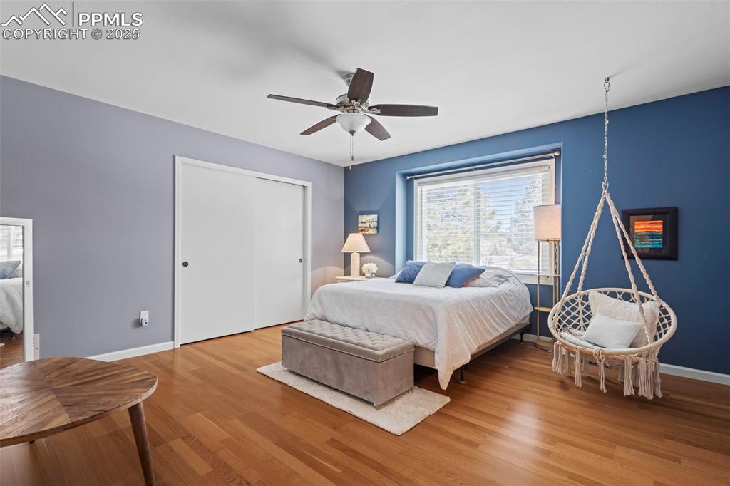 Image 27 of 49: Bedroom with a ceiling fan, a closet, baseboards, and wood finished floors