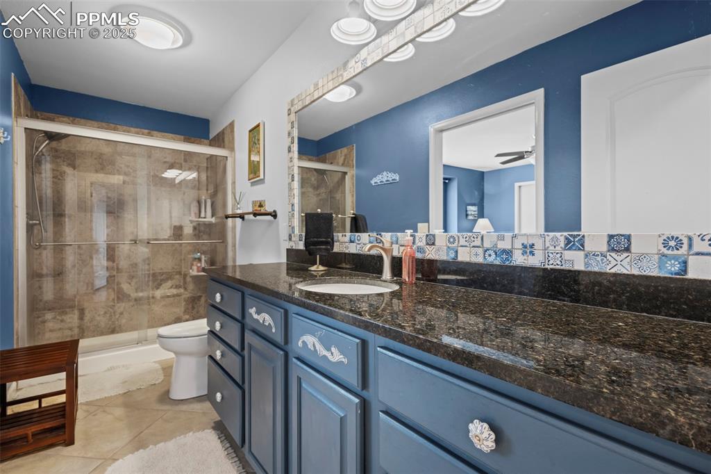 Image 28 of 49: Bathroom featuring toilet, a stall shower, vanity, and tile patterned floor