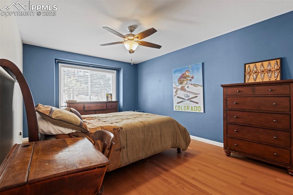 Image 29 of 49: Bedroom featuring light wood-type flooring, baseboards, and a ceiling fan