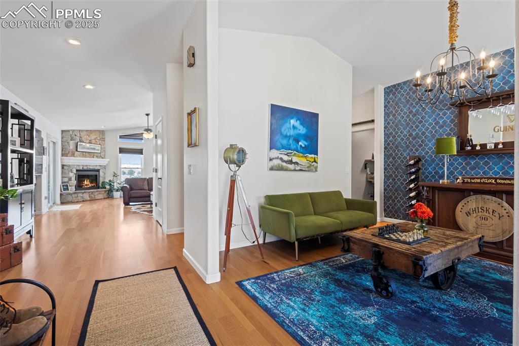 Image 3 of 49: Living area featuring lofted ceiling, an accent wall, a fireplace, wood fin