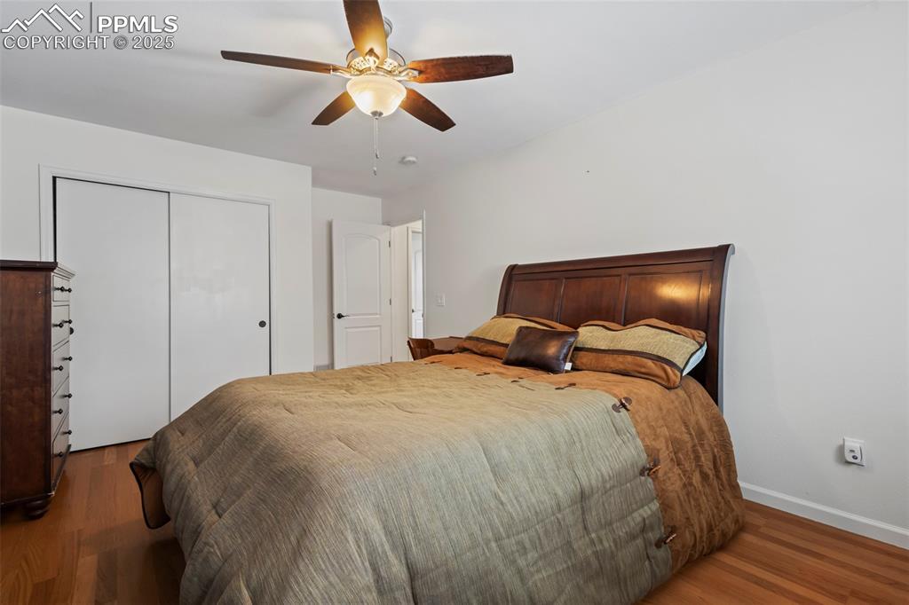 Image 30 of 49: Bedroom featuring a closet, wood finished floors, a ceiling fan, and basebo