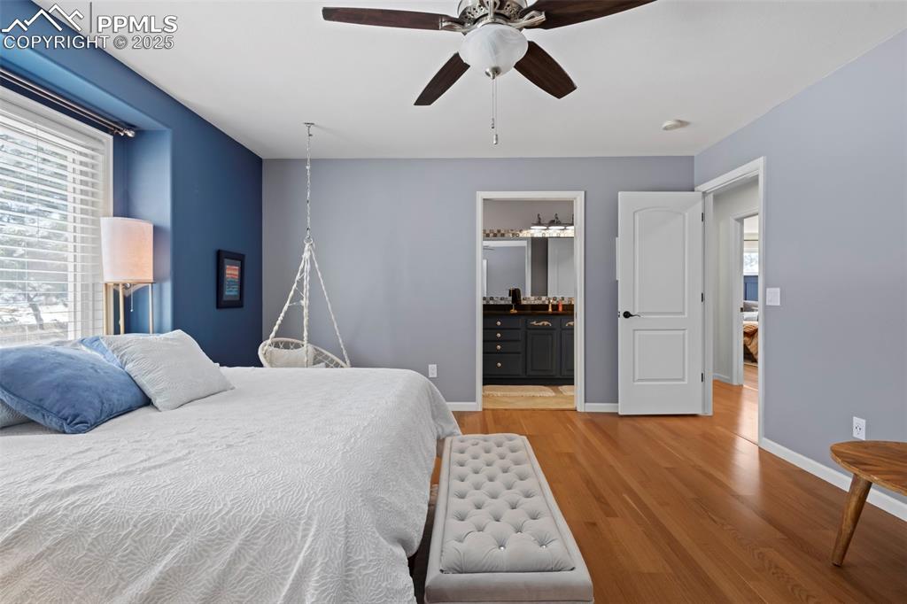 Image 31 of 49: Bedroom featuring ceiling fan, multiple windows, baseboards, and wood finis
