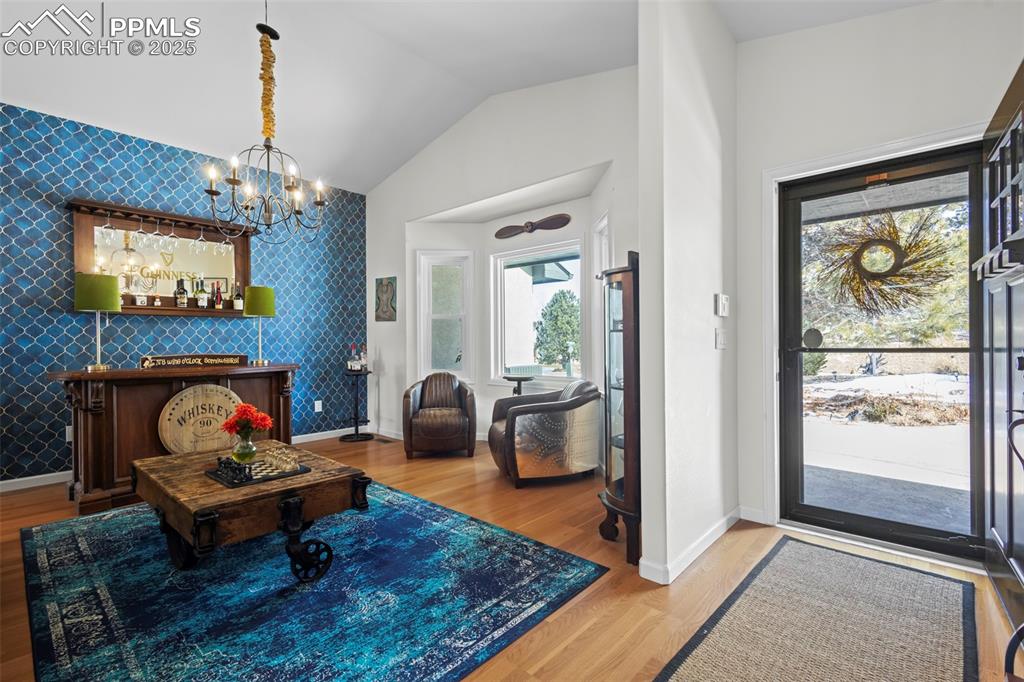 Image 4 of 49: Foyer entrance featuring wallpapered walls, an accent wall, and wood finish