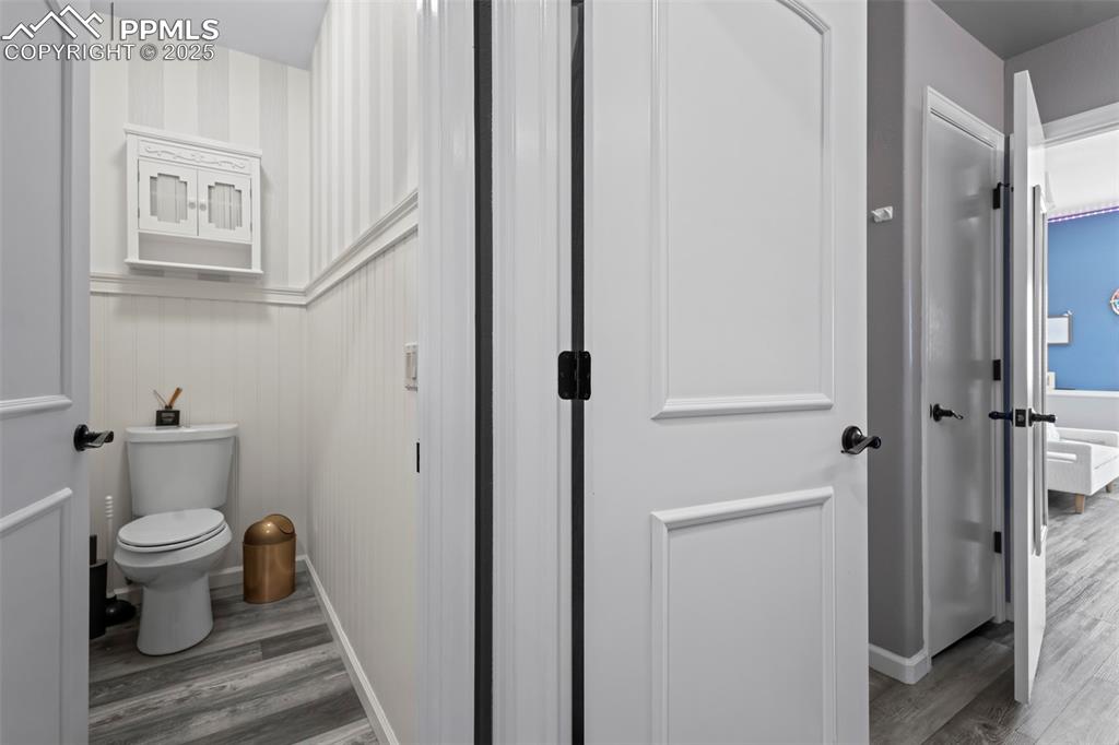 Image 42 of 49: Bathroom featuring toilet, baseboards, and wood finished floors
