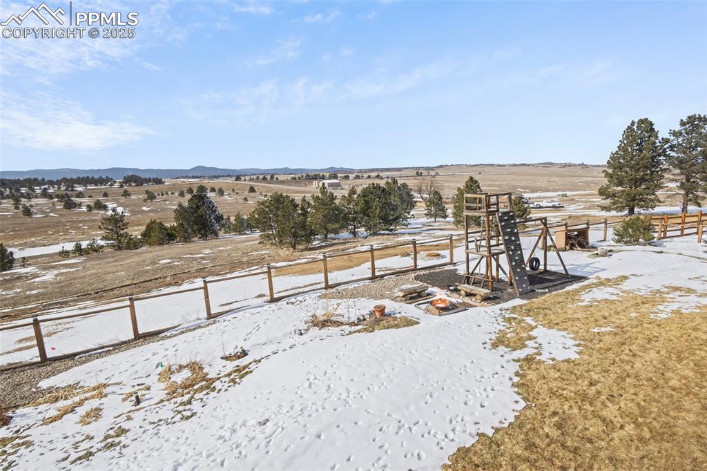 Image 46 of 49: View of yard featuring fence, a mountain view, a playground, and a rural vi