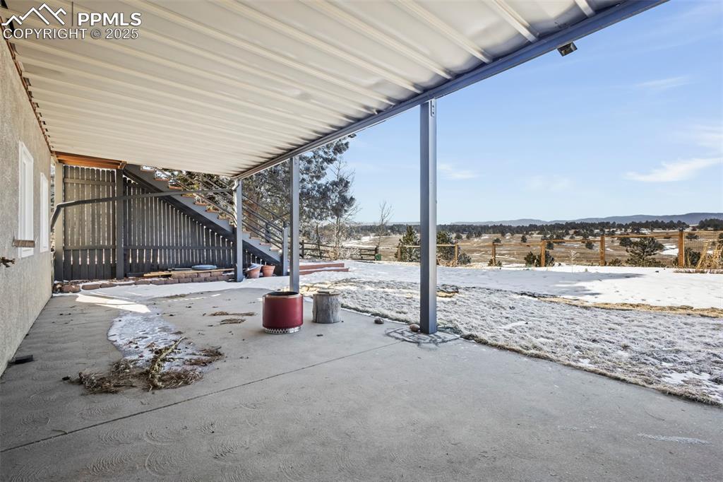 Image 48 of 49: Snow covered patio with stairway