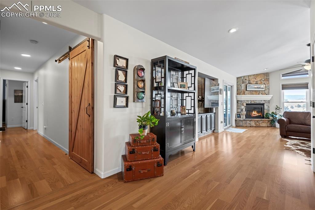 Image 7 of 49: Corridor with a barn door, recessed lighting, wood finished floors, and bas