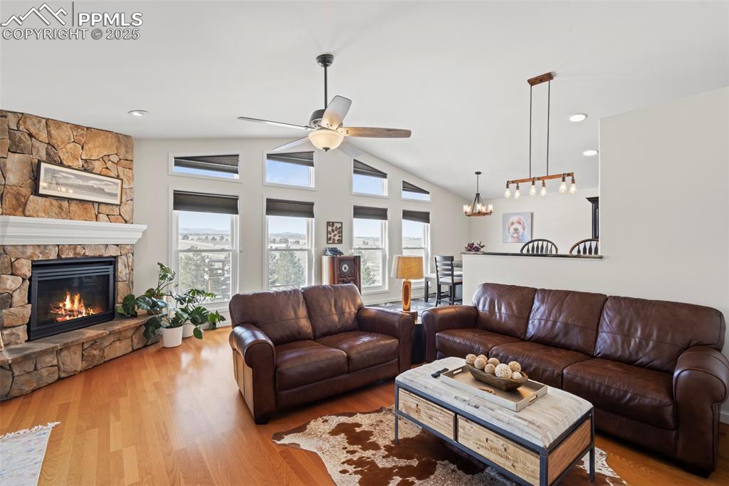 Image 8 of 49: Living area with lofted ceiling, light wood-style floors, a fireplace, and 