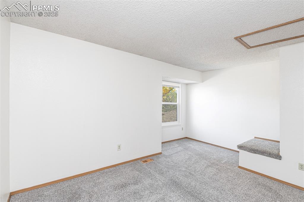 Image 13 of 31: Carpeted spare room featuring a textured ceiling and baseboards