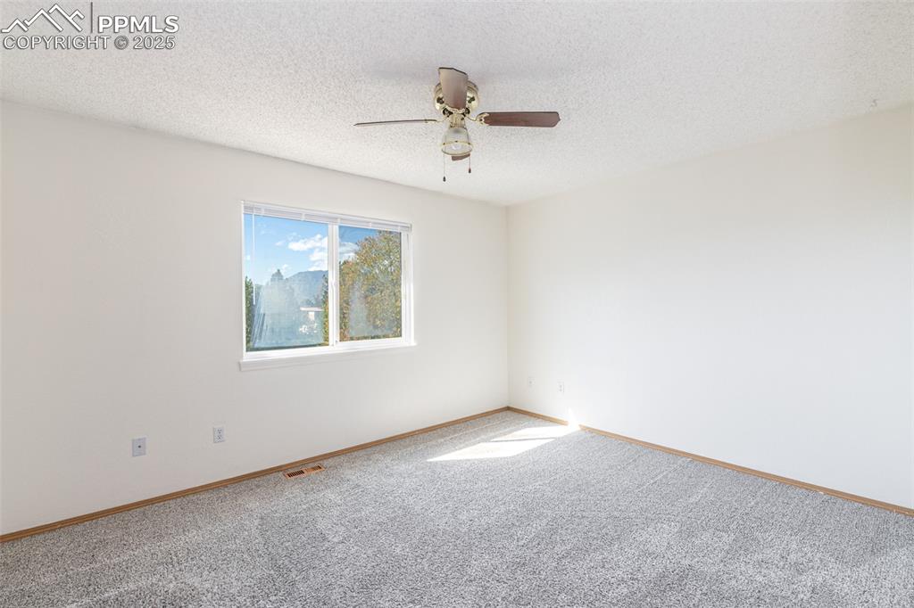 Image 15 of 31: Carpeted spare room featuring a textured ceiling and a ceiling fan