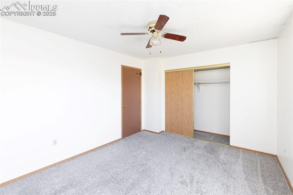 Image 16 of 31: Unfurnished bedroom with carpet flooring, a textured ceiling, a ceiling fan