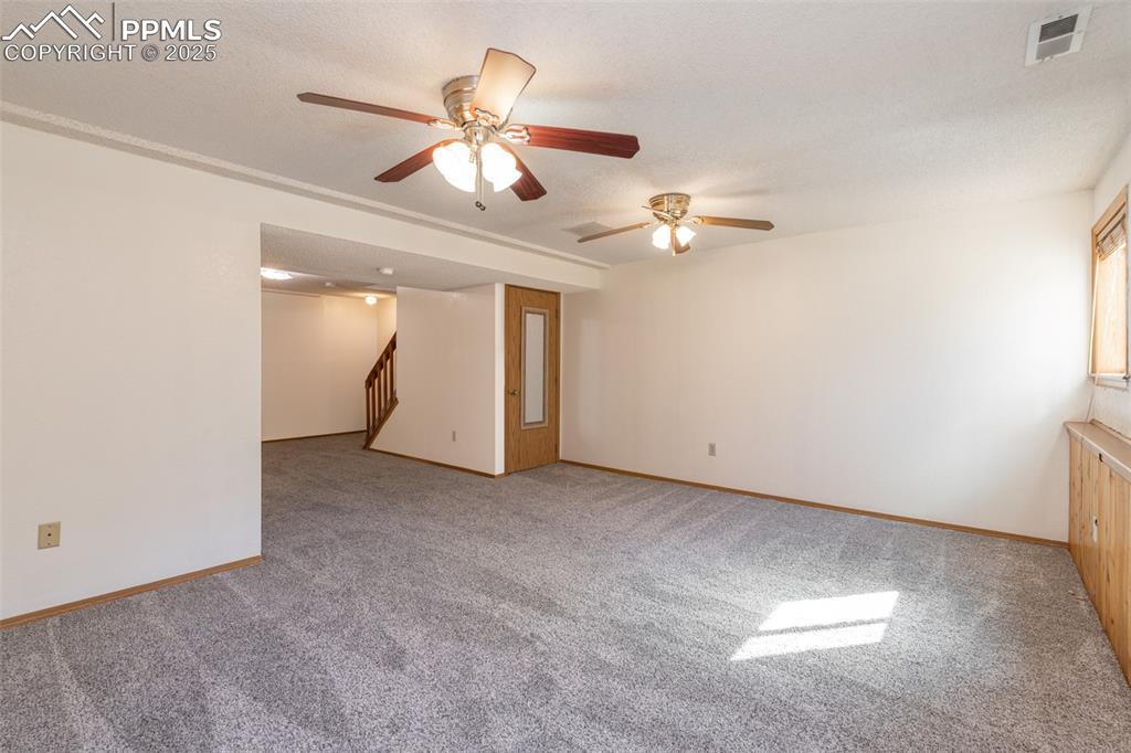 Image 21 of 31: Empty room with a ceiling fan, light colored carpet, and a textured ceiling