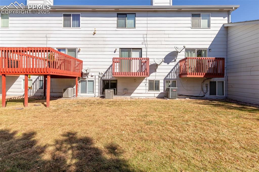 Image 26 of 31: Rear view of property featuring a chimney, a lawn, and a patio area
