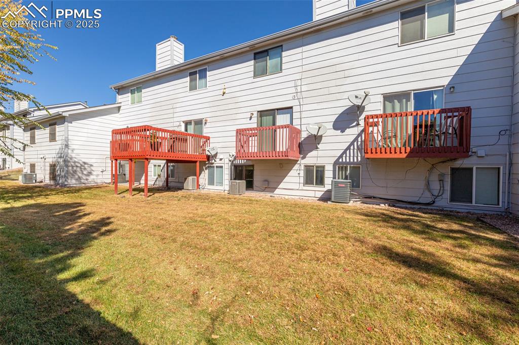 Image 27 of 31: Rear view of property with a chimney, a yard, a patio, and a balcony