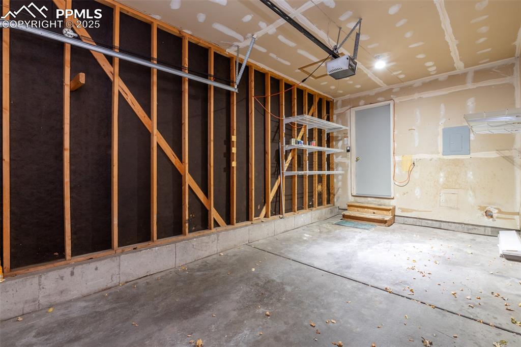 Image 31 of 31: Garage with electric panel and a garage door opener