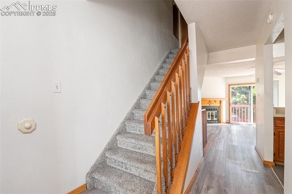 Image 5 of 31: Stairs with wood finished floors and a textured ceiling